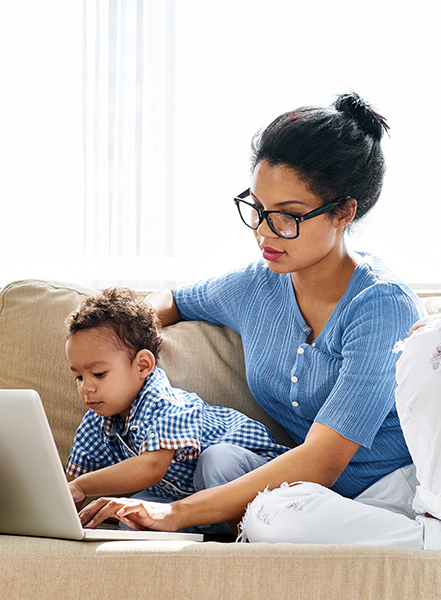 picture genetics - newsletter - A Women and baby siting on a couch both interacting with a laptop.